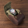 étui de voyage pour montres 1 place en cuir vegan marron sur table en bois