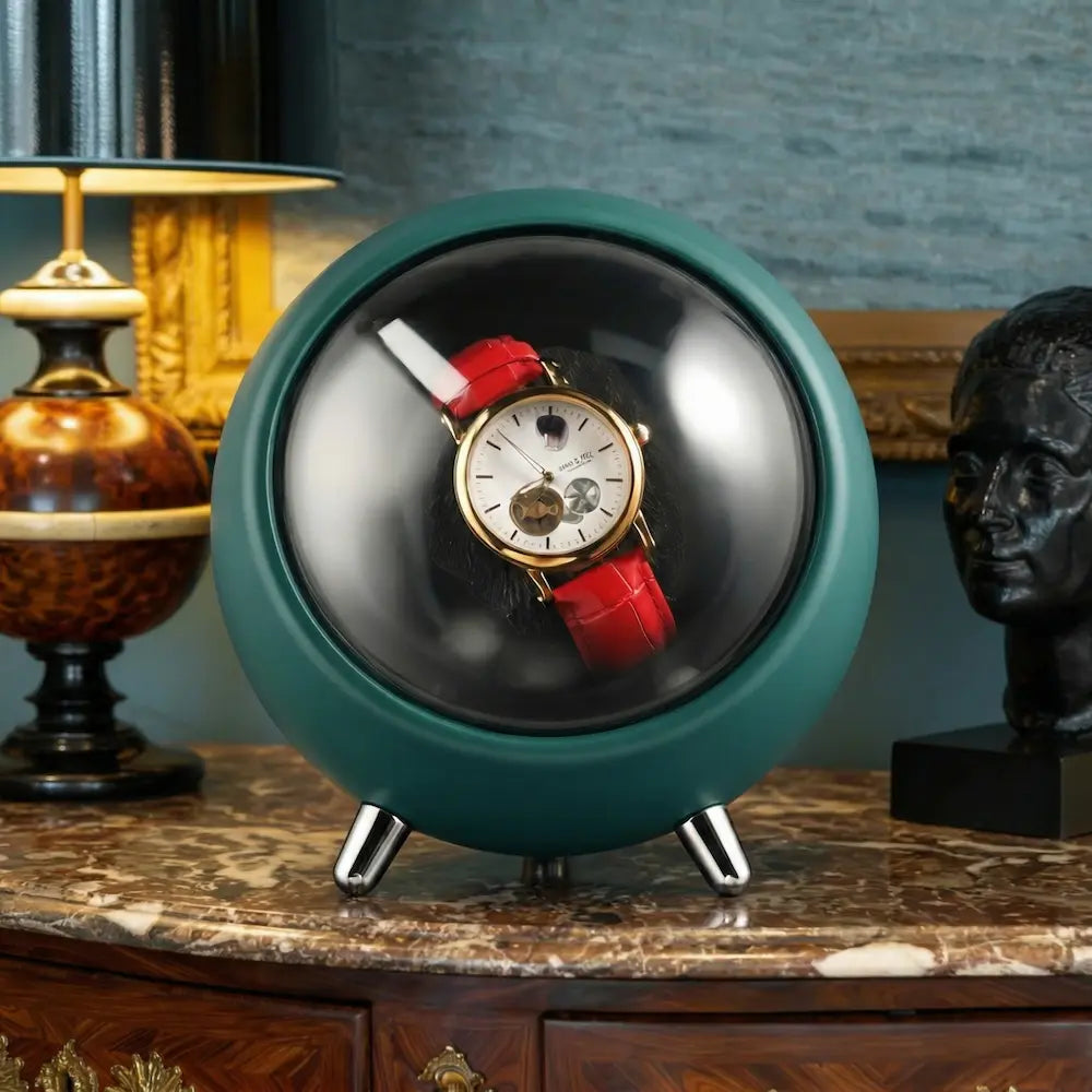remontoir pour montres couleur vert foncé en forme de sphère sur meuble